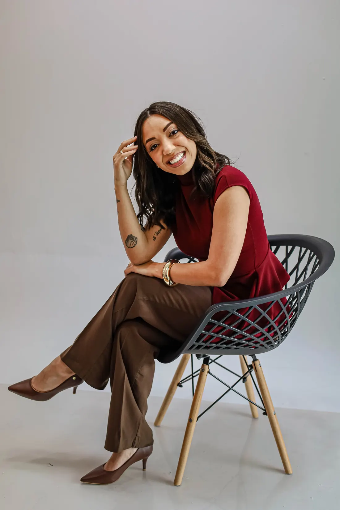 Thayna Souza, psicóloga, sentada sorrindo